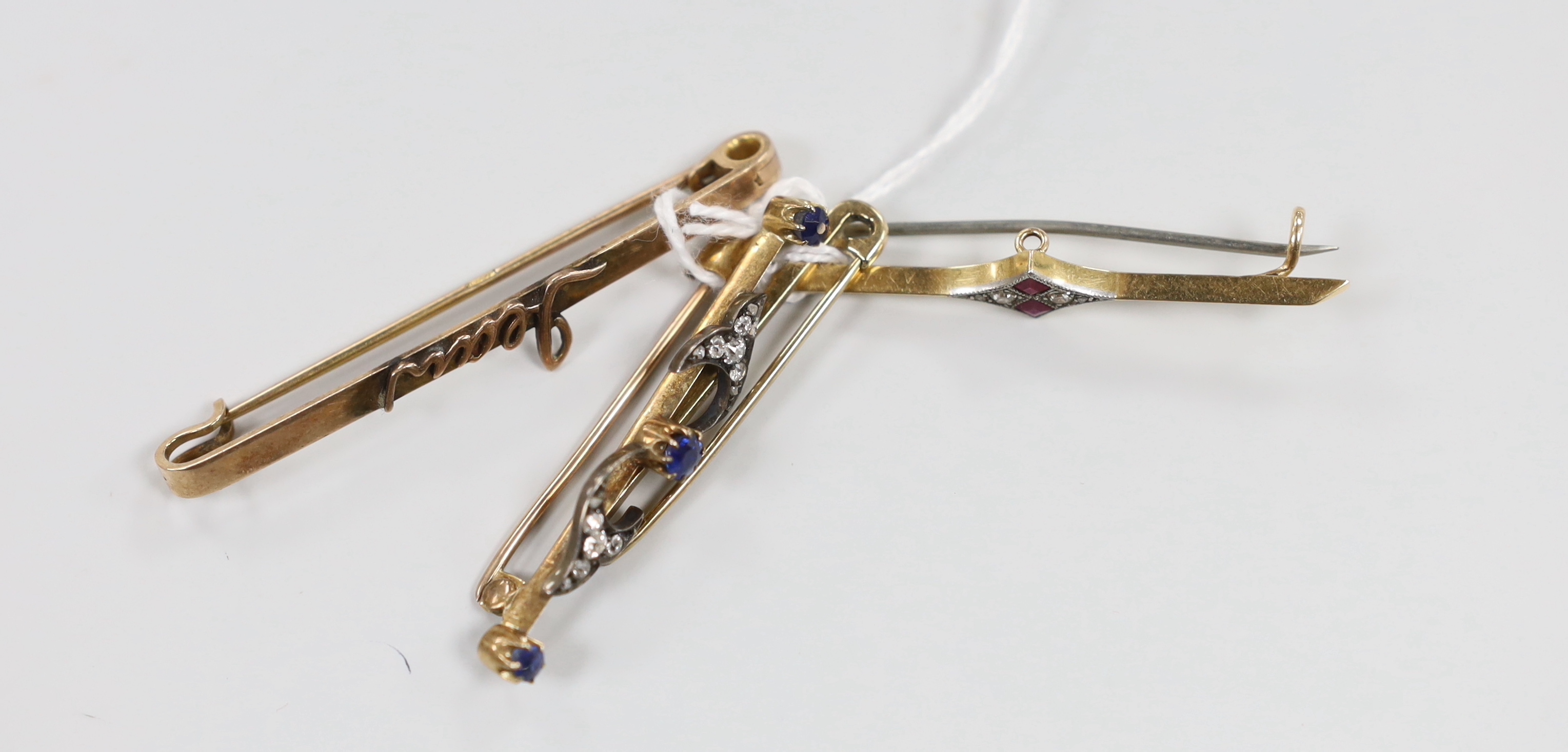 An Edwardian 15ct, ruby and diamond set bar brooch, 48mm, gross weight 3.3 grams, a similar yellow metal, sapphire and diamond cluster set bar brooch and two 9ct bar brooches, gross weight 9.3 grams.